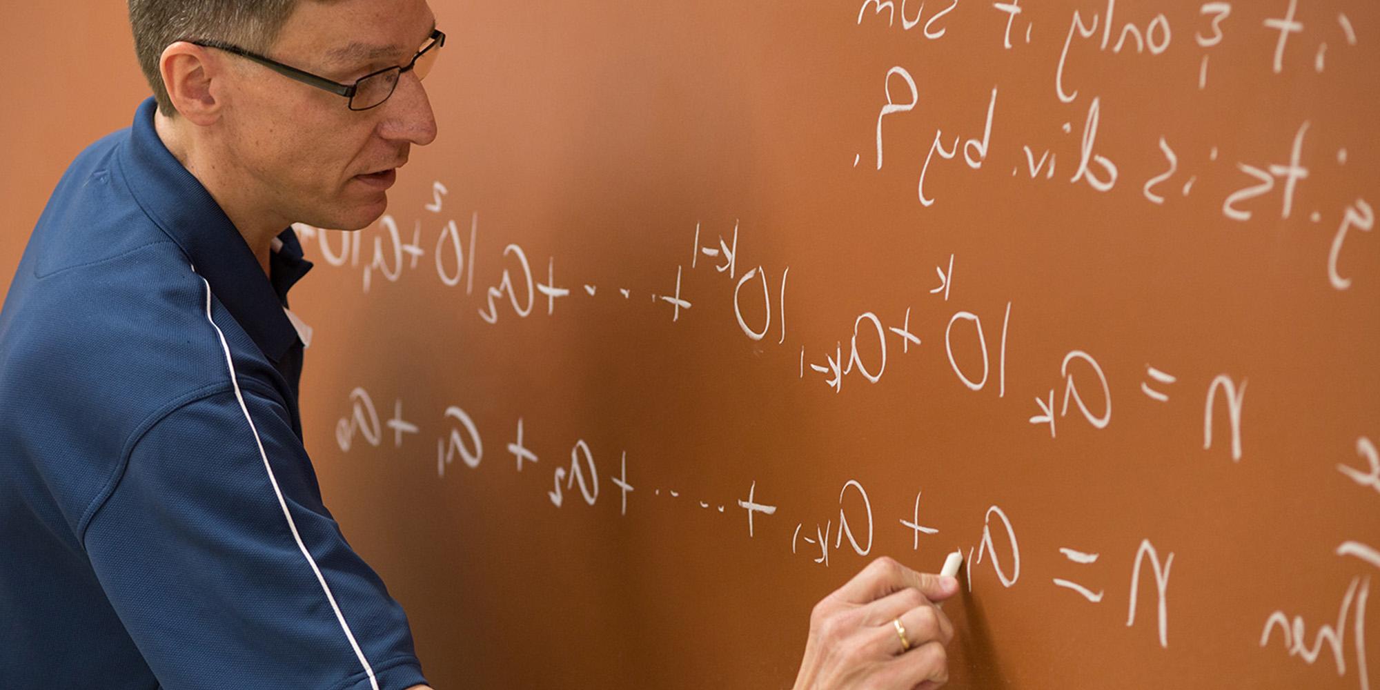 Math Professor Writing Equation On A Chalkboard